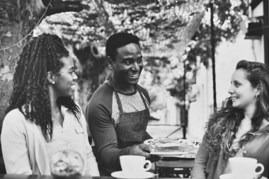 Genç garson iki tatlı kadına servis yapıyor.