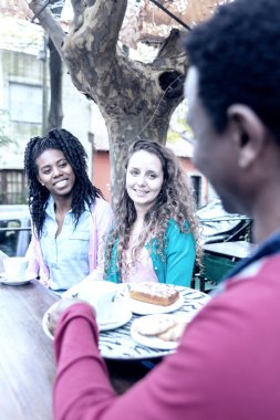 Siyah garson tarafından servis edilen iki genç kadın için kahve ve bisküvi..