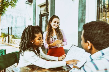 Birkaç genç Afrikalı erkek arkadaş kahve dükkanındaki garsona sipariş vermiş..