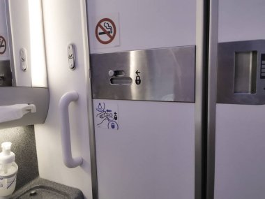 İçerideki uçağın tuvaletinin kapısı. Hava alanının içindeki alışveriş merkezi.