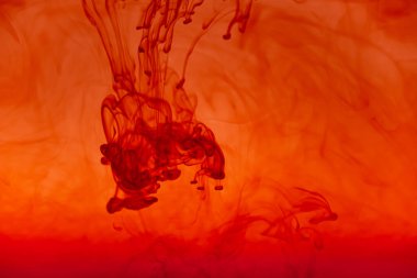 Kırmızı renkli mürekkep sıvısını kapat ve soyut arkaplan dumanı tüttür. Suda akan renk damlası.