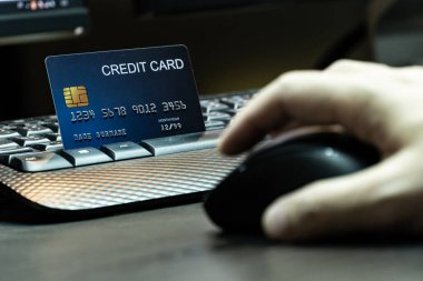 Yüzeysel odaklı, el ele tutuşan, kredi kartı ve bilgisayar geçmişi olan fareyi kapat. E-ticaret ve çevrimiçi alışveriş konsepti.