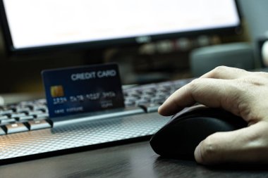 Yüzeysel odaklı, el ele tutuşan, kredi kartı ve bilgisayar geçmişi olan fareyi kapat. E-ticaret ve çevrimiçi alışveriş konsepti.