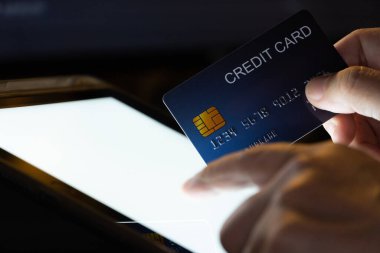 Tablet ekranındaki parmak izi kredi kartını ateşle. Cep telefonu teknolojisi ve aygıtı kavramı.