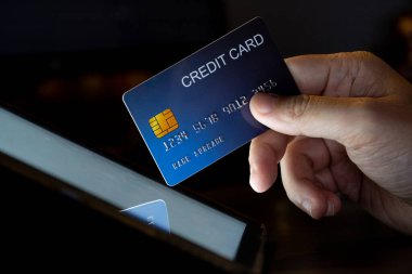 Tablet ekranındaki parmak izi kredi kartını ateşle. Cep telefonu teknolojisi ve aygıtı kavramı.