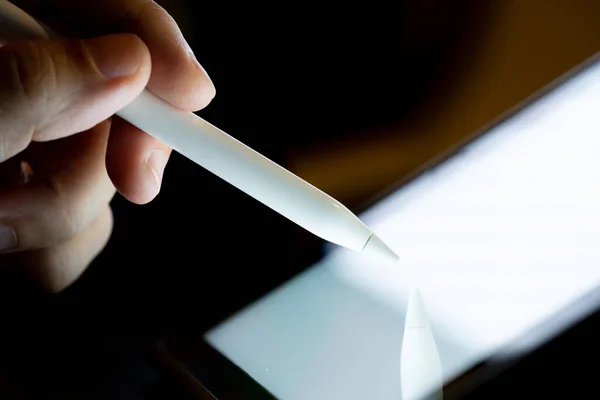 Hand use  pen stylus touch and drow on Tablet screen Mock up with light. Concept for mobile phone technology and future look.