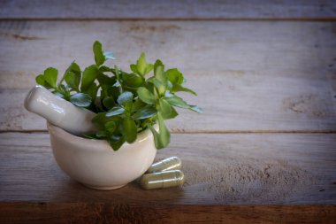 Alternatif ilaç şifalı bitkiler, havan topları, laboratuvar camları, ahşap bir arka planda..