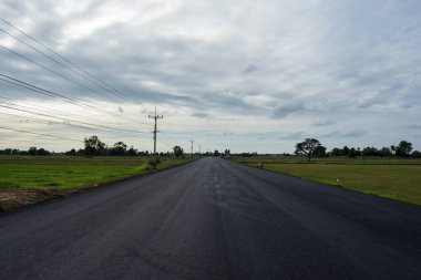 Mavi gökyüzü ve beyaz gökyüzünün atmosferinde inşa edilen yol.