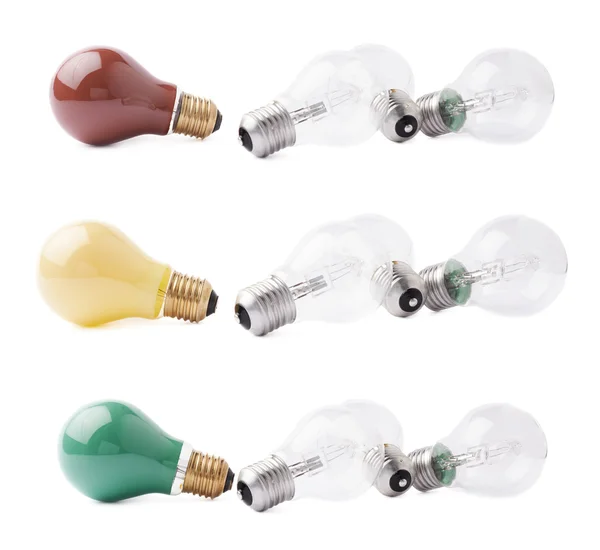 Colored bulbs lying next to couple of transparent bulbs over white isolated background — Stock Photo, Image