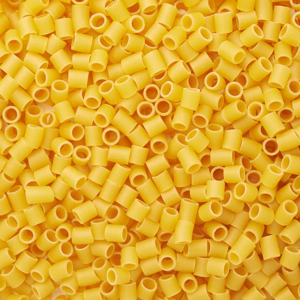 Куча ditalini желтой пасты в качестве абстрактного фона — стоковое фото