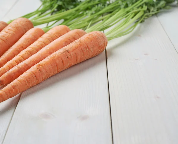 Rå hel morot på ytan träbord — Stockfoto