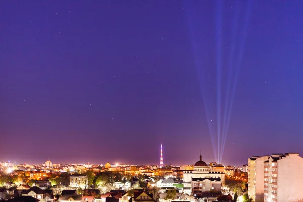 Night Illuminated City View Light Rays Shine Dark Purple Sky — Stock Photo, Image
