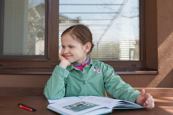 Het Kleine Meisje Een Groen Shirt Leert Thuis Maar Kijkt — Stockfoto