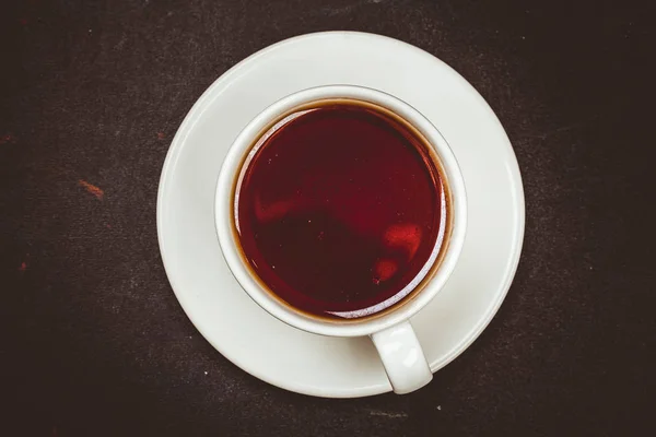 Csésze tea, fekete felület. — Stock Fotó