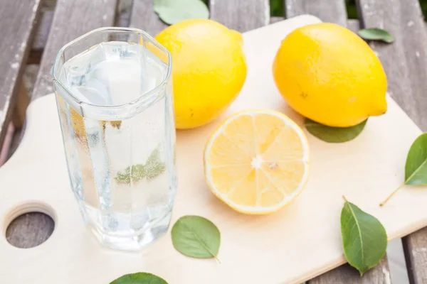 Lemon, glass water cutting board — Stock Photo, Image