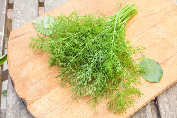 Dill on wooden cutting board — Stock Photo, Image