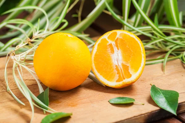 orange fruit, leaf, wooden cutting