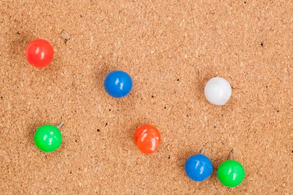 Coloured thumbtack pins on brown — Stock Photo, Image