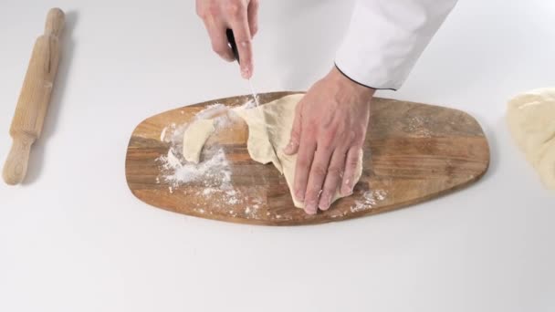 Top view of chef on white table slicing dough into pieces. Close up. — Stock Video