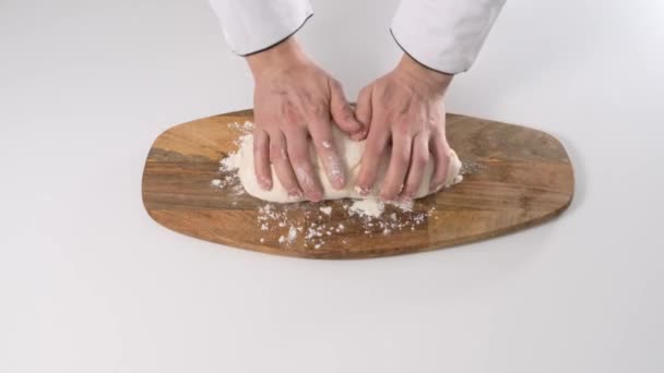 Männliche Hände kneten Teig in Mehl auf einem Tisch und einem Holzbrett. Nahaufnahme. — Stockvideo