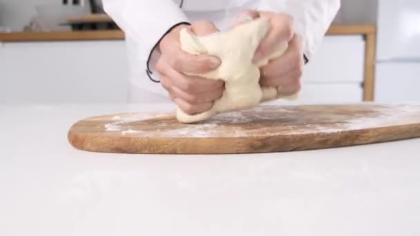 As mãos masculinas amassam a massa de farinha em uma mesa e tábua de madeira. Fechar . — Vídeo de Stock