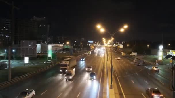 Κυκλοφορία που ρέει κατά μήκος ενός τρόπου το βράδυ. Τα αυτοκίνητα οδηγούν. — Αρχείο Βίντεο