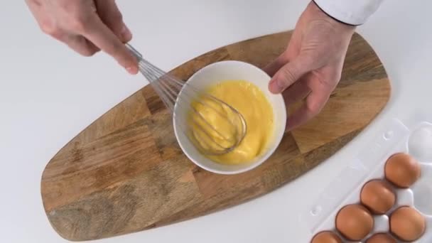 Kochen Mischung mit Schneebesen Eier auf weißem Tisch. Nahaufnahme. — Stockvideo