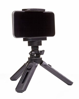 Beyaz arka planda izole edilmiş akıllı telefon için küçük siyah tripod. Kapat..