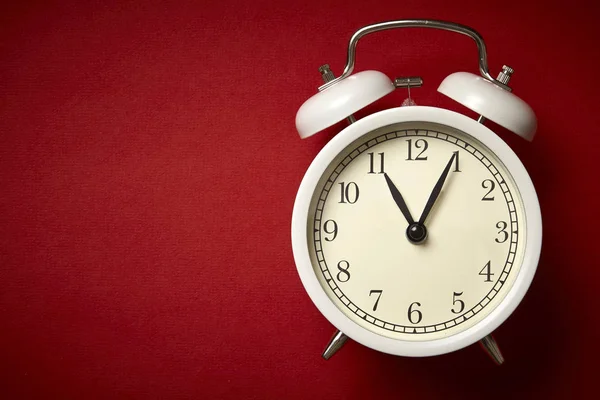 White alarm clock on red background. Close up. Top view. — Stockfoto