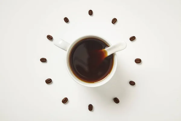 Kopje koffiebonen als een klok op een witte achtergrond. Bovenaanzicht. — Stockfoto