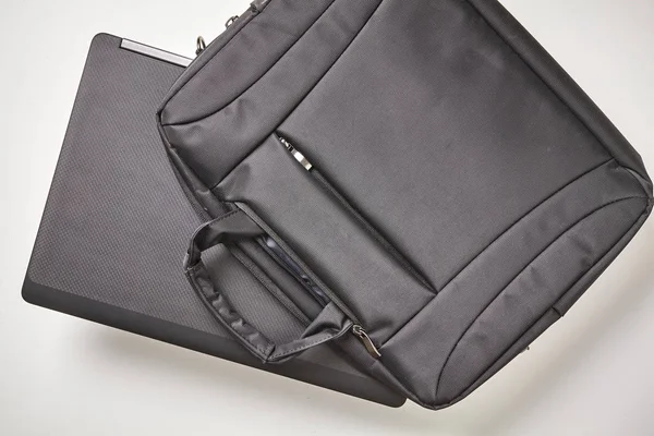 Beyaz arka planda dizüstü bilgisayarlı siyah defter çantası. Üst görünüm.
