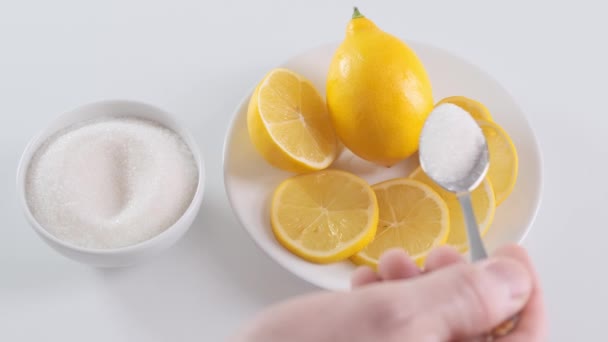 Putting sugar to sliced lemon on saucer in kitchen. Close up. — Stock Video