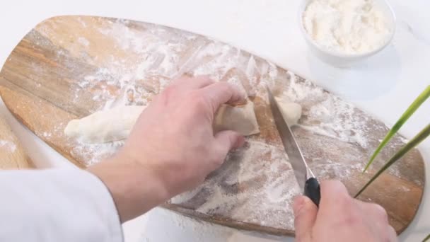 Beyaz masada hamuru parçalara ayıran şefin üst görüntüsü. Kapat.. — Stok video