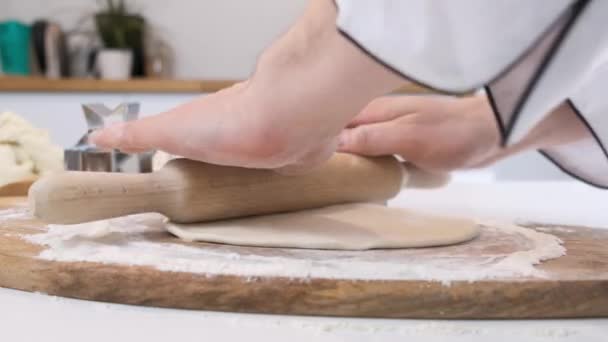 Man rolls dough with rolling pin on wooden chopping board. Close up. — Stock Video