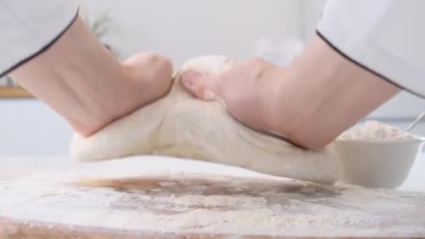 Male hands kneading dough in flour on a table and wooden board. Close up. — Stock Video