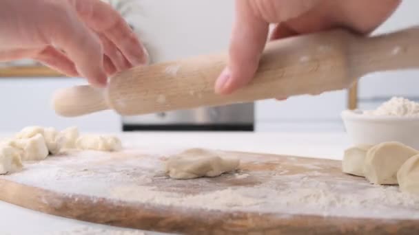 Man rolt deeg met deegroller op houten snijplank. Sluiten.. — Stockvideo