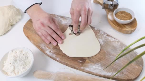 Man Cutting a Star Shaped Cookie out of Cookie Dough on white table with wooden board. Close up. — 비디오