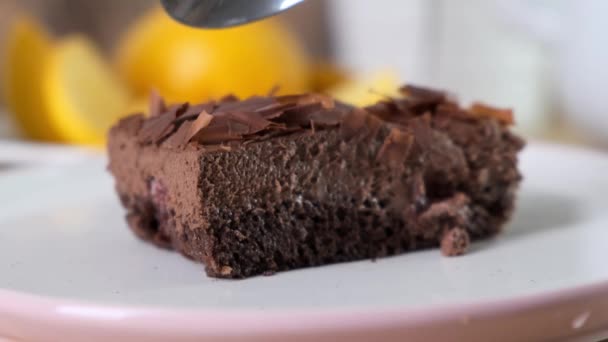 Вкусный шоколадный торт с ложкой на столе, крупным планом — стоковое видео