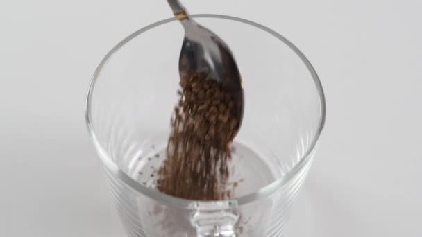 Colher com puor de café instantâneo em uma caneca branca em um fundo preto. Movimento lento . — Vídeo de Stock