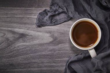 Ahşap arka planda, tekstil ve fotokopi alanlı beyaz kahve. Üst görünüm.