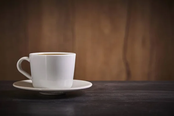 Witte kop koffie op bruine houten achtergrond met kopieerruimte. Sluiten.. — Stockfoto