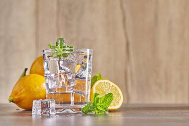 Limonlu, naneli ve ahşap masadaki buzlu su. Kapat..