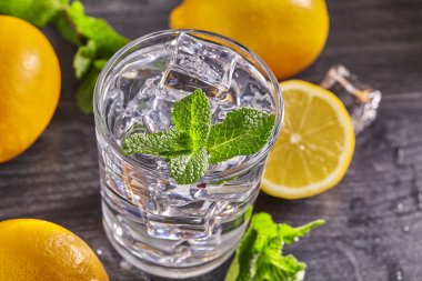 Limonlu, naneli ve ahşap masadaki buzlu su. Kapat..