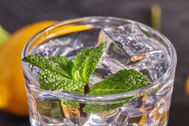 Limonlu, naneli ve ahşap masadaki buzlu su. Kapat..