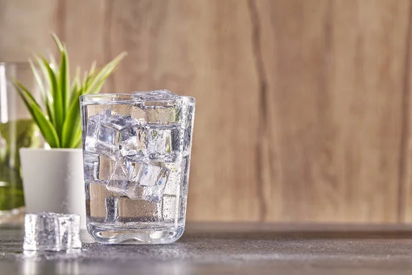 Glass transparent of water with ice on wood background. Close up. — Stock Photo, Image