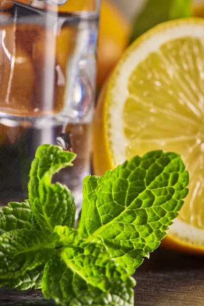 Wasser mit Zitrone, Minze und Eis auf einem Holztisch. Nahaufnahme. — Stockfoto