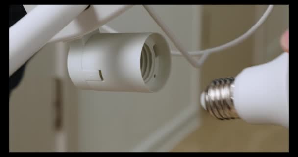 Mains de Mans Remplacement d'une ampoule dans la lampe. Gros plan . — Video