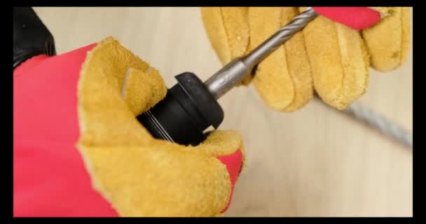 Ο εργάτης αλλάζει το τρυπάνι με γάντια. Κλείσε.. — Αρχείο Βίντεο