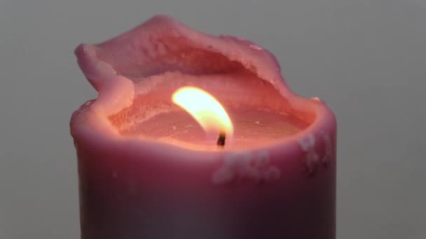 Hermoso fuego de una vela en un cuarto oscuro. De cerca. . — Vídeos de Stock