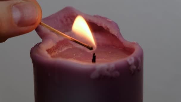 Las manos femeninas de primer plano encienden una vela por fósforo de madera en la oscuridad, en cámara lenta — Vídeo de stock